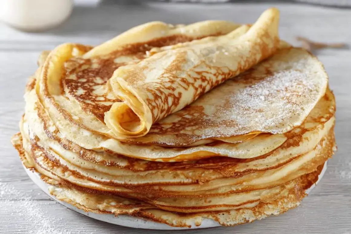 Ein Stapel goldbrauner Pfannkuchen, bestäubt mit Puderzucker. Ein perfektes Pfannkuchen Rezept für jeden Anlass.