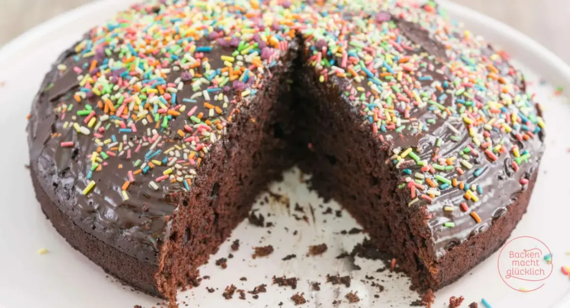 Schokoladenkuchen ohne Ei, üppig mit bunter Streusel-Deko und Schokoladenglasur. Ein Genuss für alle, die es süß mögen!