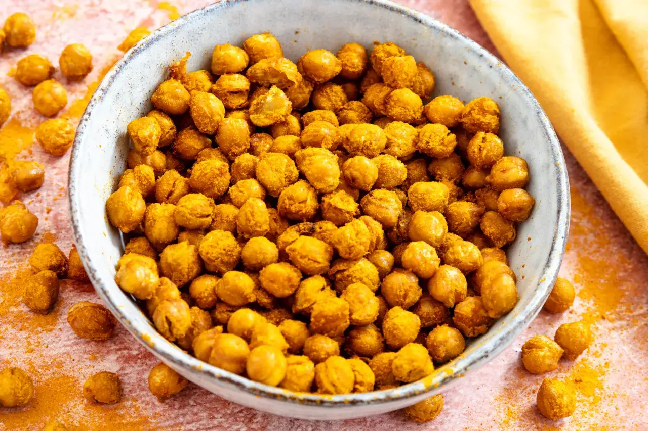Ger&ouml;stete Kichererbsen aus der Dose, gew&uuml;rzt mit Kurkuma, liegen in einer Schale. Ein leckerer Snack, der schnell zubereitet ist.